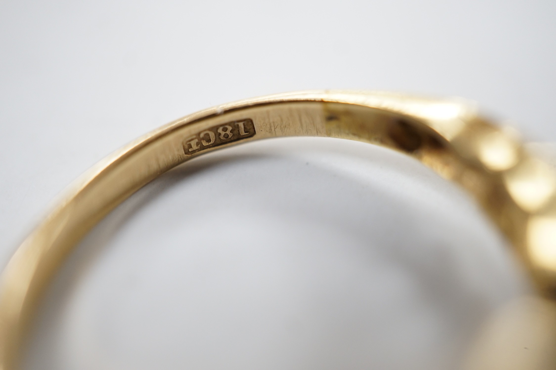 An 18ct and nine stone diamond set table ring, with pierced shoulders, size M/N, gross weight 3.7 grams.